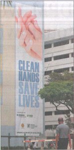 Huge hand hygiene poster on the wall of SGH in 2009. Image from: http://www.sgh.com.sg/about-us/newsroom/News-Articles-Reports/2009/Pages/sgh-steps-clean-hands-campaign-straits-times-thu-pg-b6.aspx